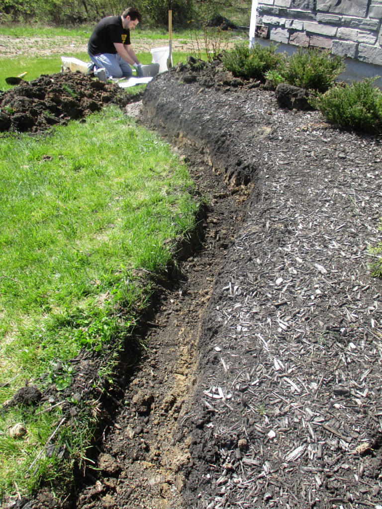 digging a trench to edge out a flower bed