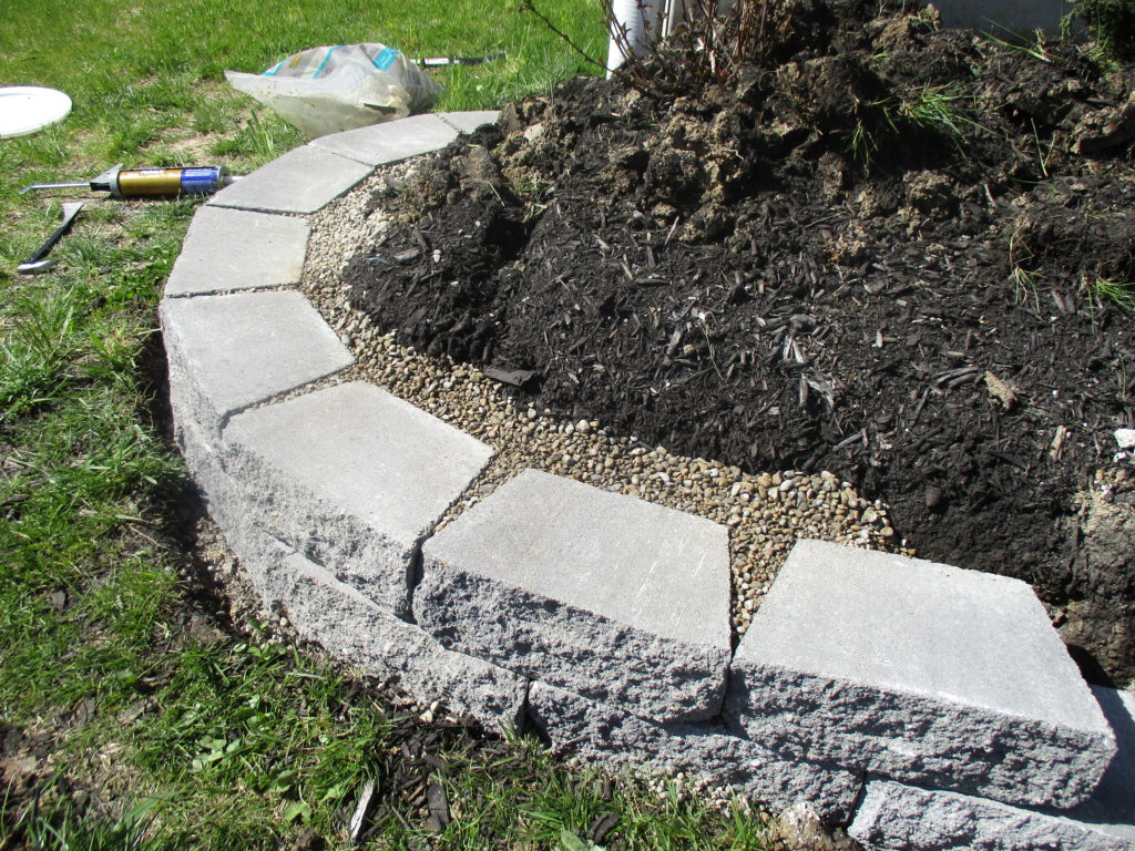 getting started laying stone for our retaining wall flower beds