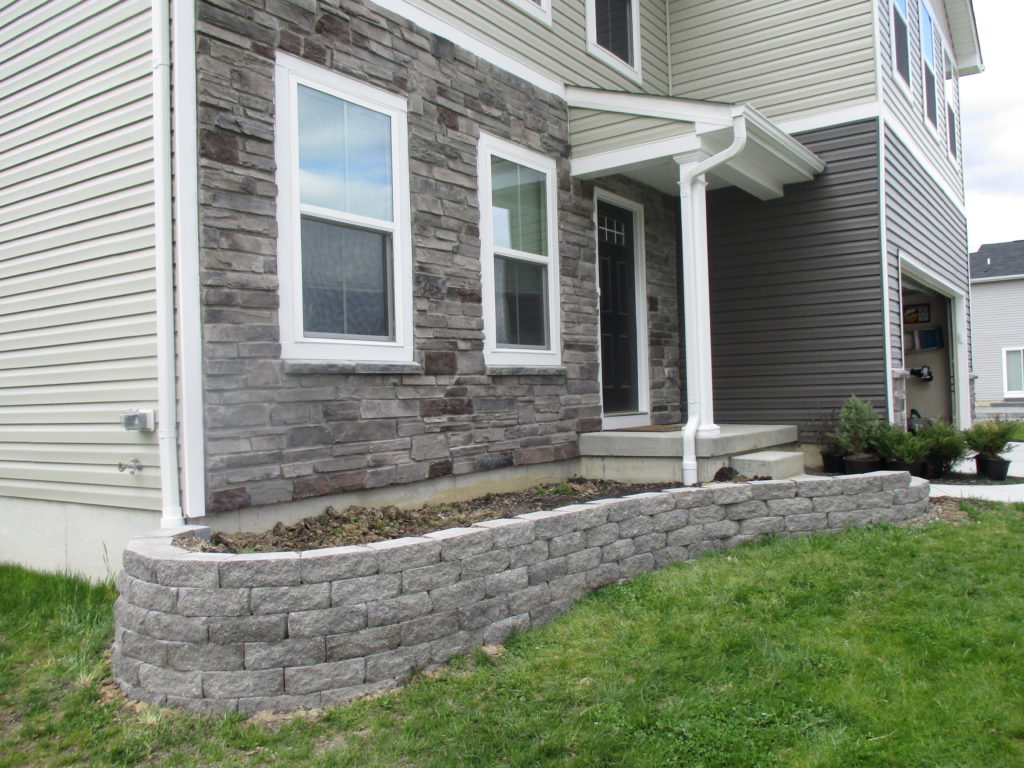 front yard makeover with stone retaining wall being built