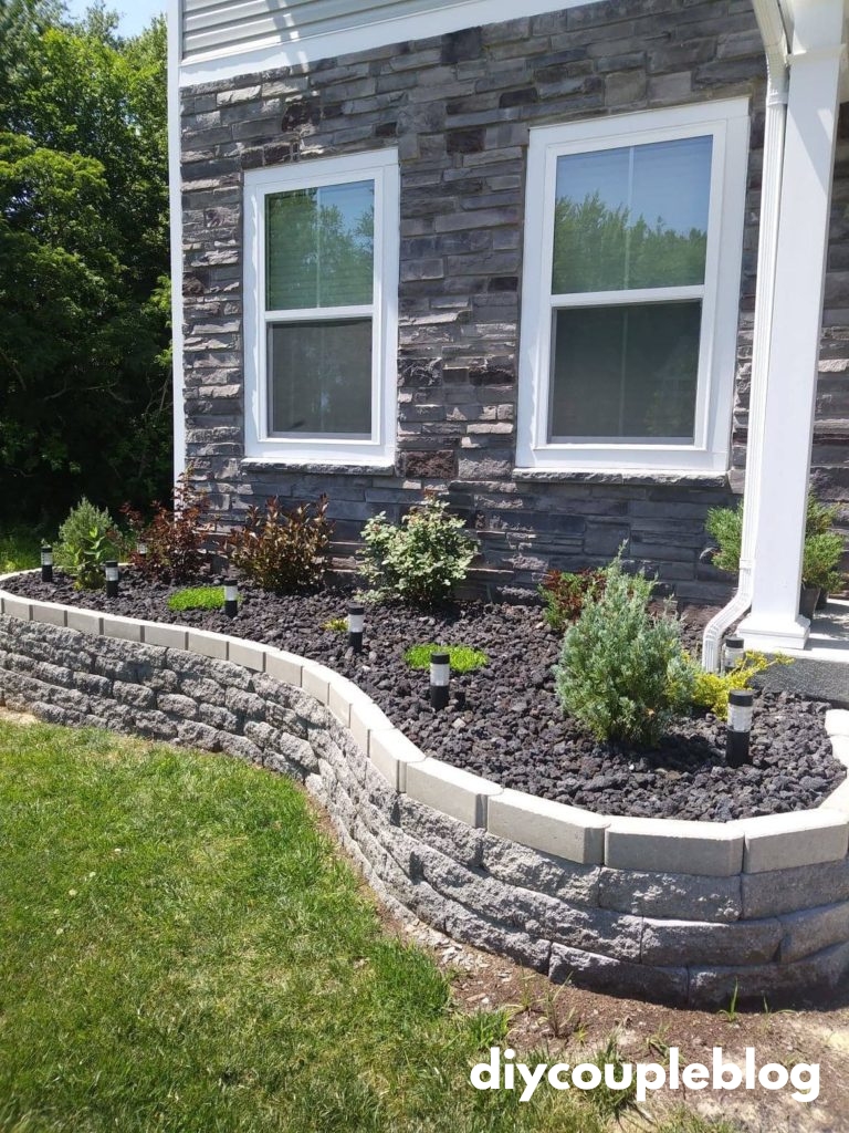 front yard flower bed with concrete retaining wall and lava rocks