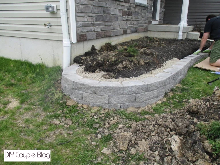 stacking gray slate stones for a modern DIY retaining wall 