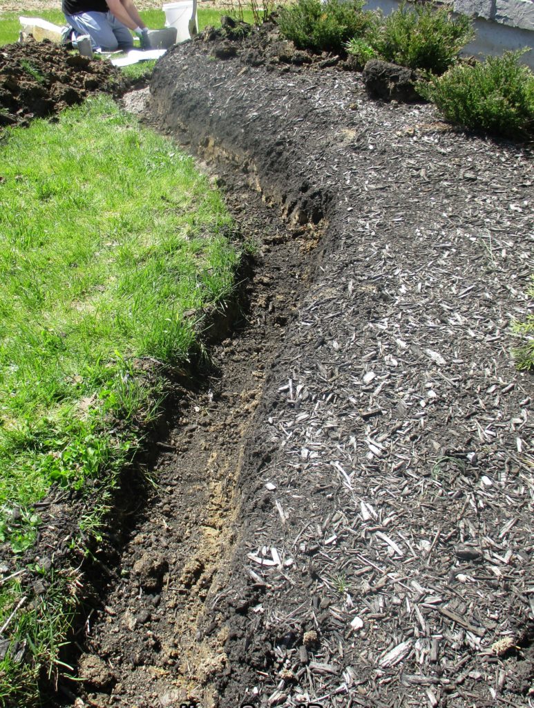 digging a trench for retaining wall on a slope