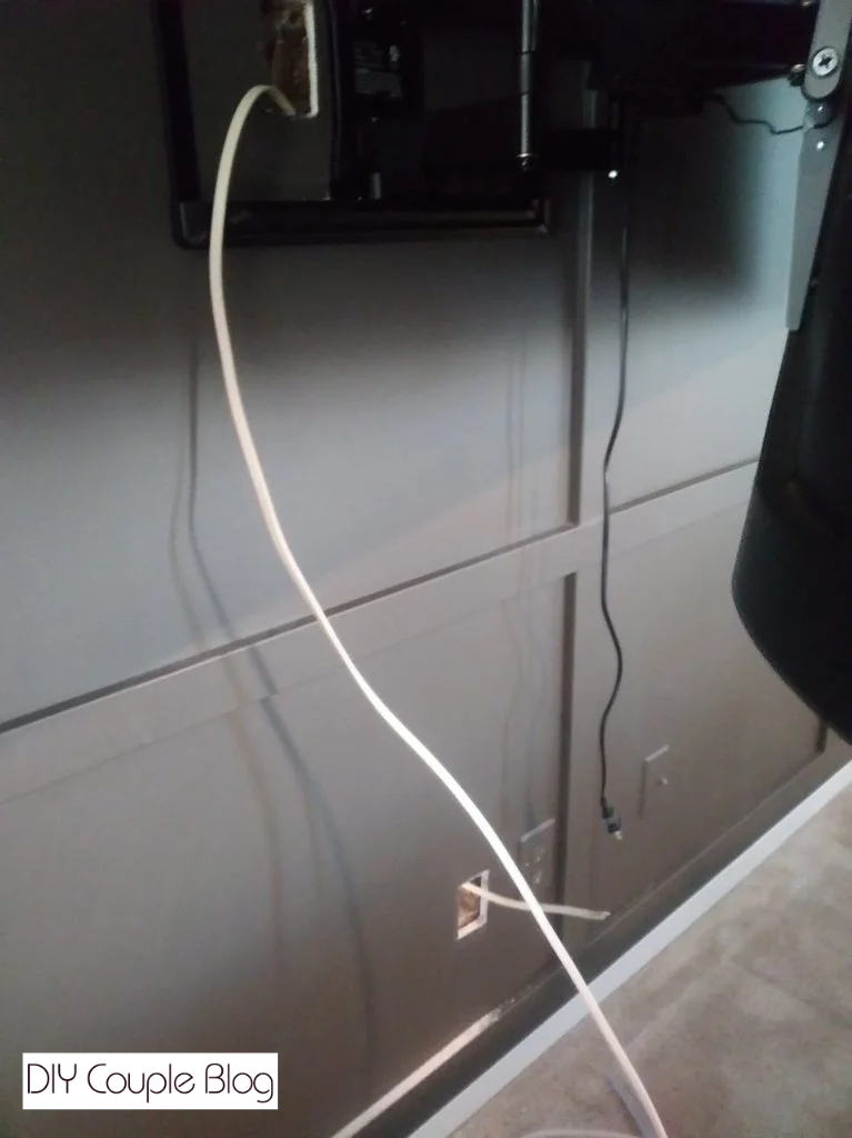 Fishing the cord out the bottom hole for hiding wires for wall mount TV