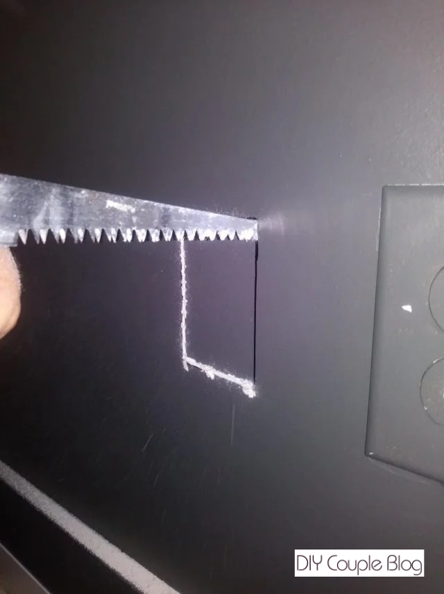 cutting into the drywall with a drywall saw