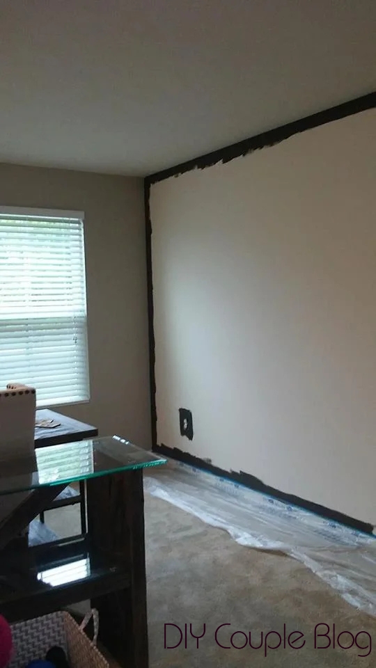 cutting in edges on a dark gray living room accent wall.