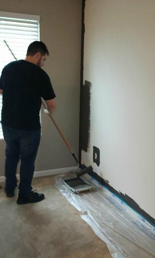 my husband painting the wall in the dark color