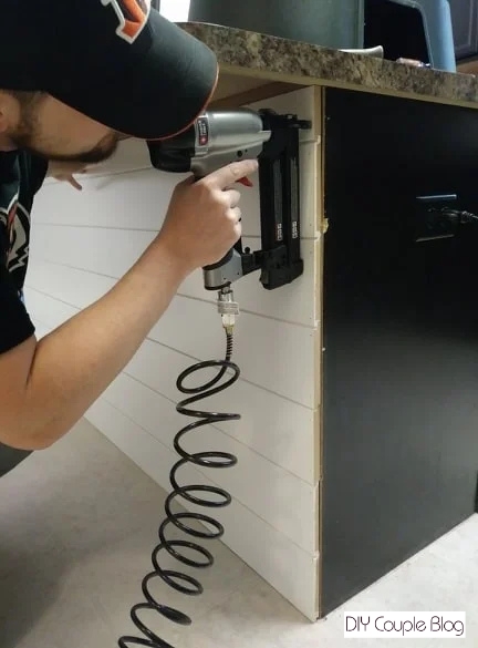 homeowner using a tool to attach the boards 
