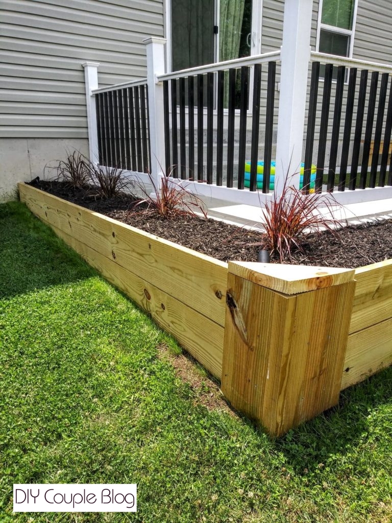 side view showing the purple grass in a wood raised bed wrapping around the patio