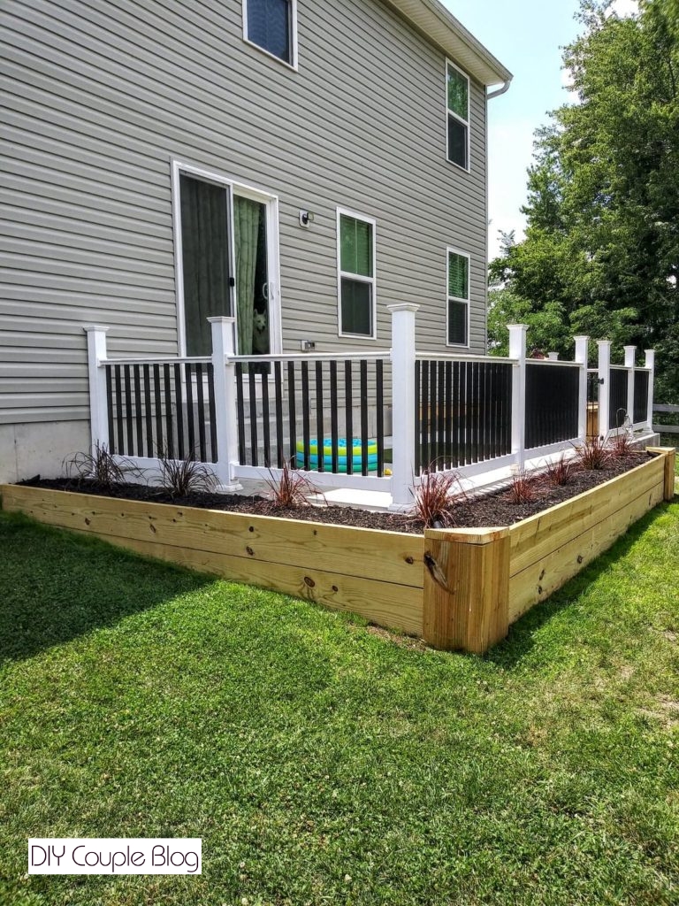 DIY raised garden bed made of lumber wrapped around a patio