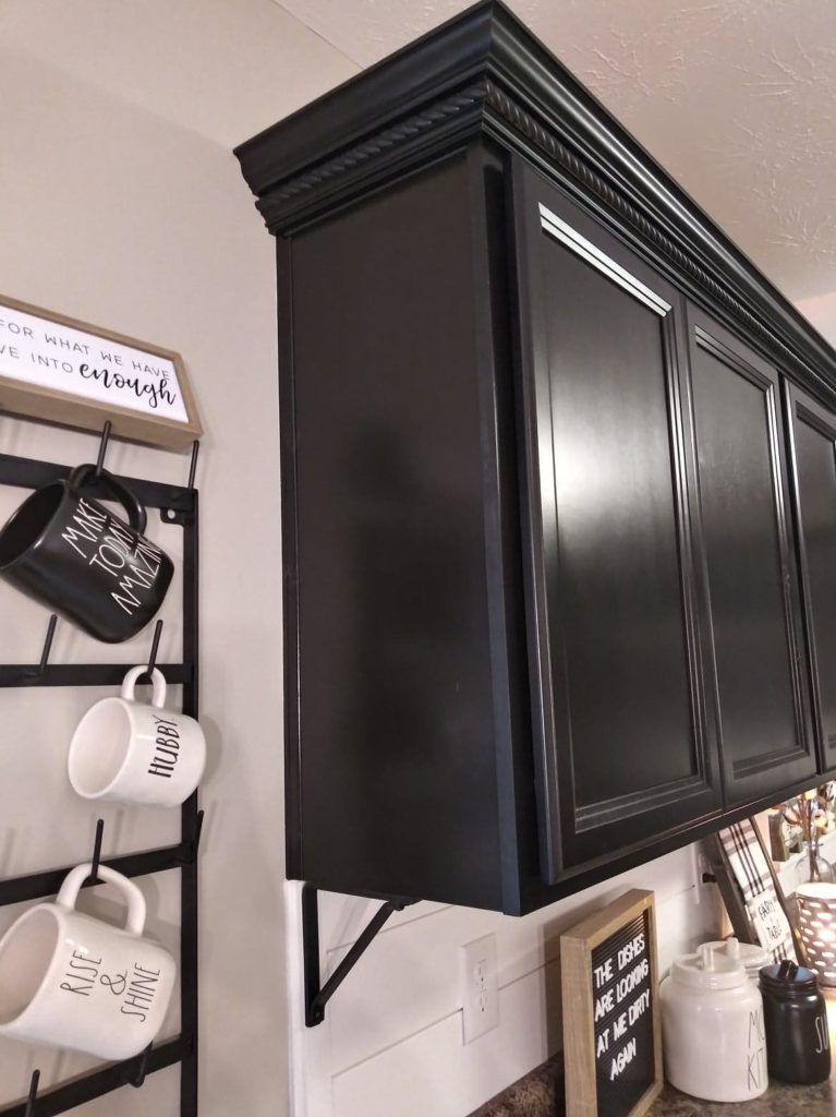 crown molding on top of black kitchen cabinets