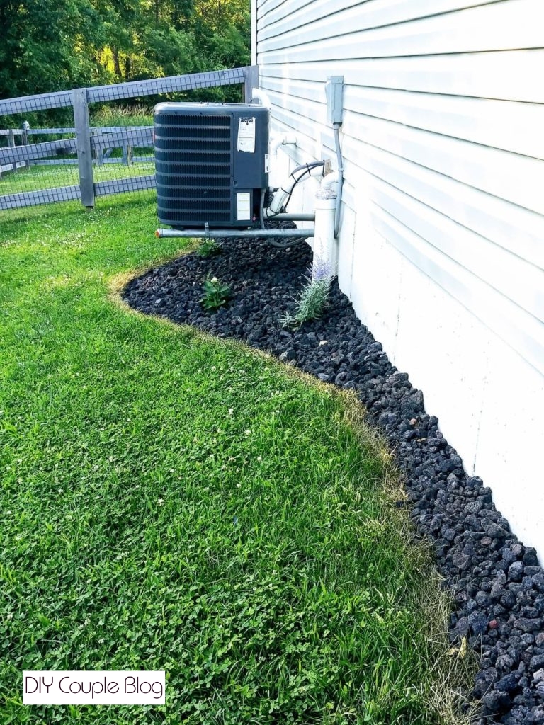 view looking down the side of the house landscaping with black rock