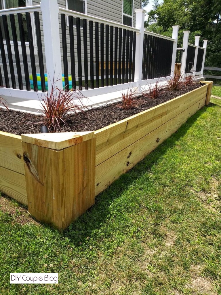 adding topsoil, mulch then the firework fountain grass for our wood raised beds