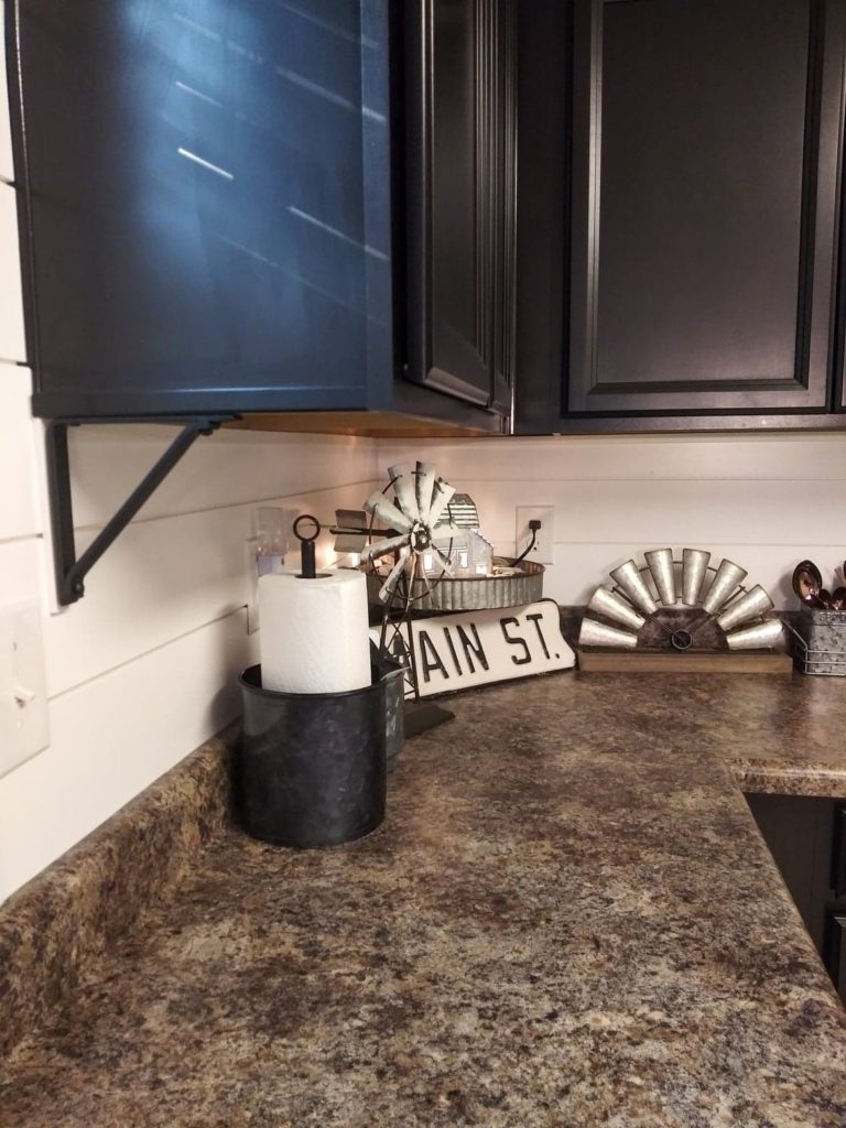 farmhouse kitchen with black cabinets and white shiplap