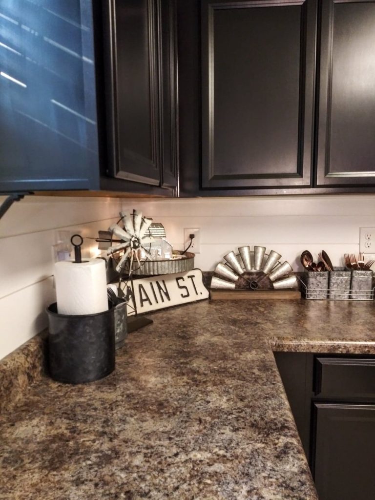 black cabinets with a shiplap backsplash and farmhouse decor