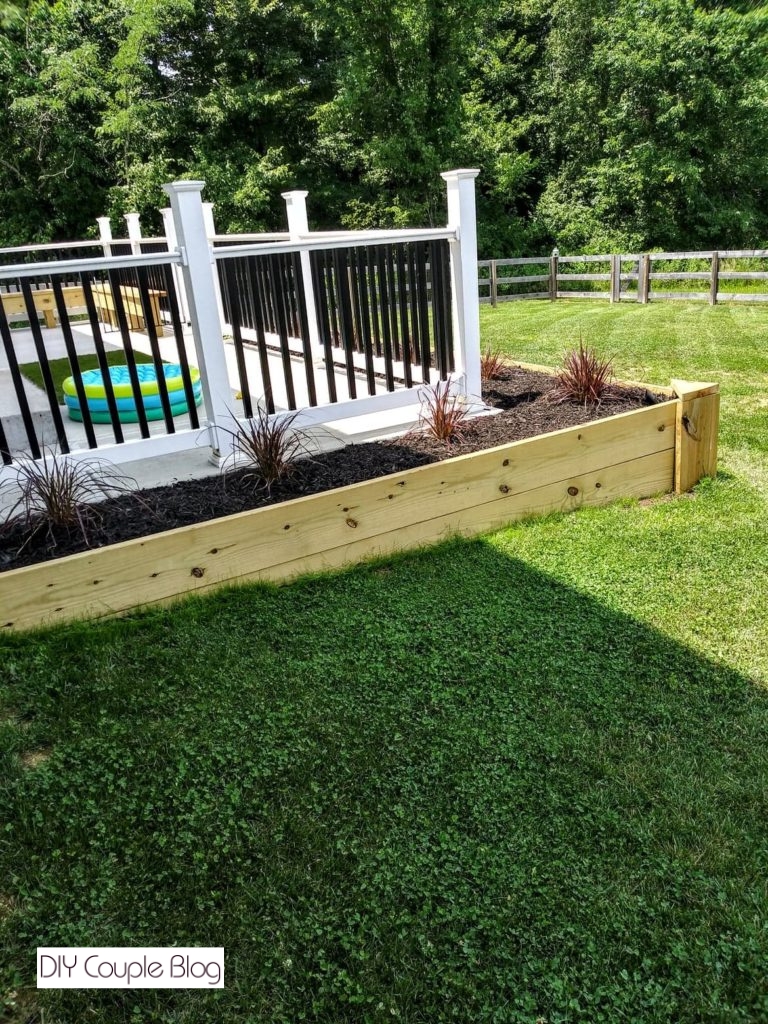 wood raised bed in our backyard wrapping around the back patio
