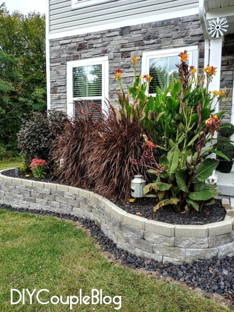 flower bed with decorative black lava rocks going around the edge