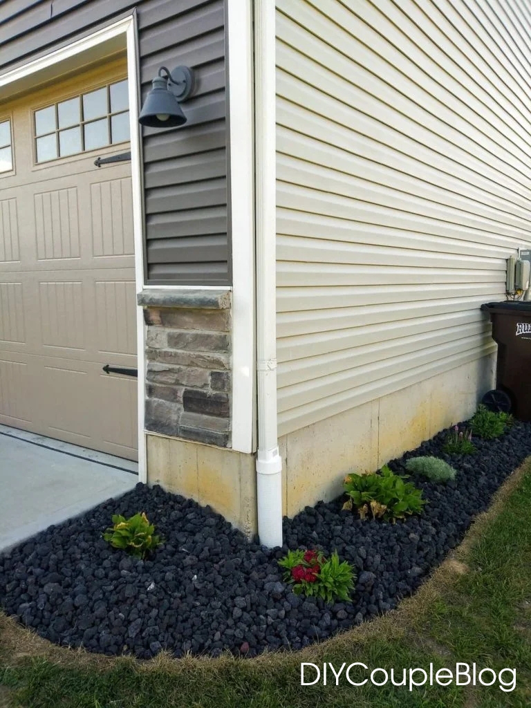 landscaping around the garage with black rock