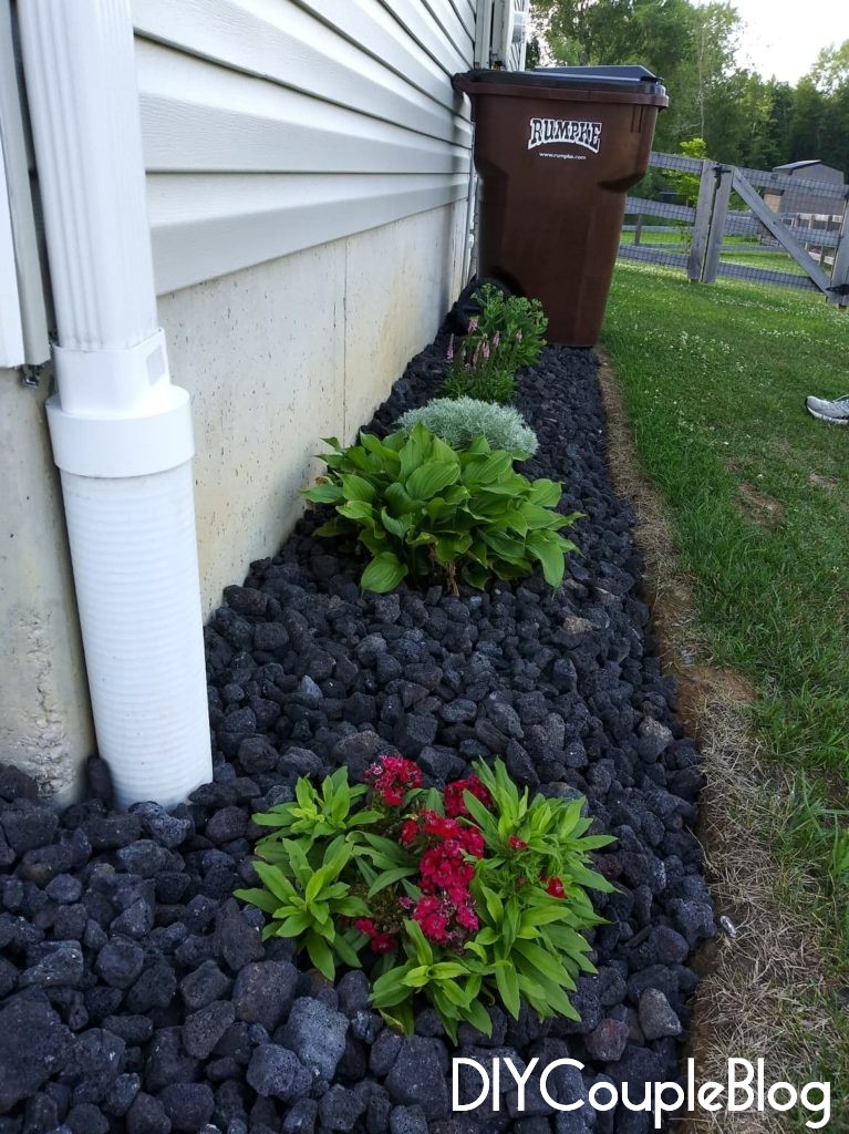 our flower bed makeover with black lava rock landscaping