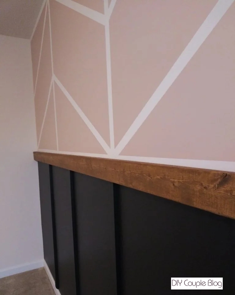 close-up view of the design featuring the pink chevron design on the top wall with a black board and batten on the bottom half