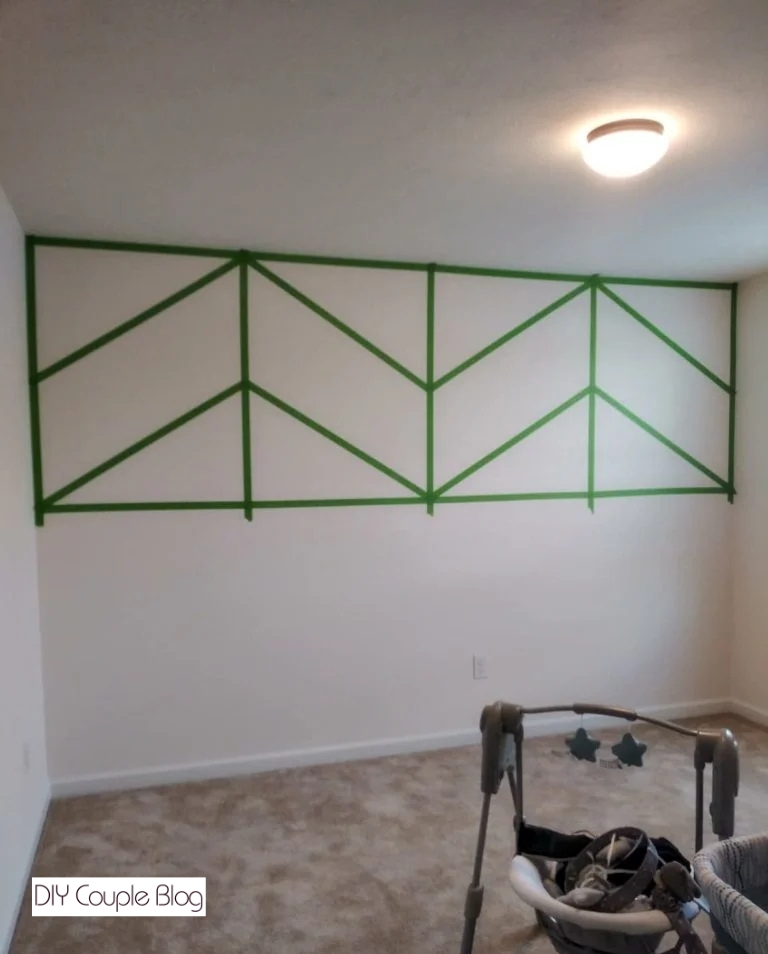 applying frog tape to the wall to create a fun design