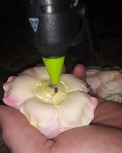 applying hot glue around the bottom of flower