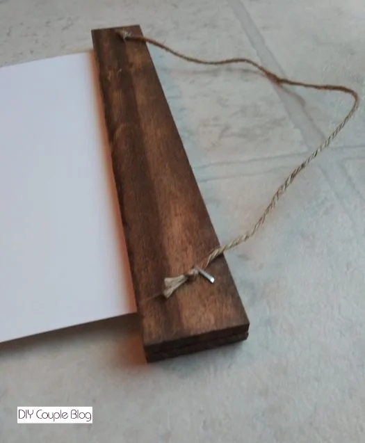 securing the string to the back of the rustic scroll frame