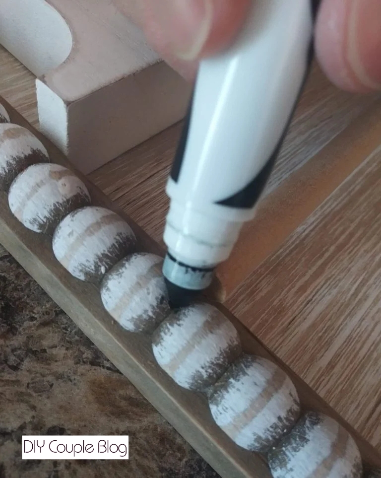 marking where the wood dowels will be secured with a marker