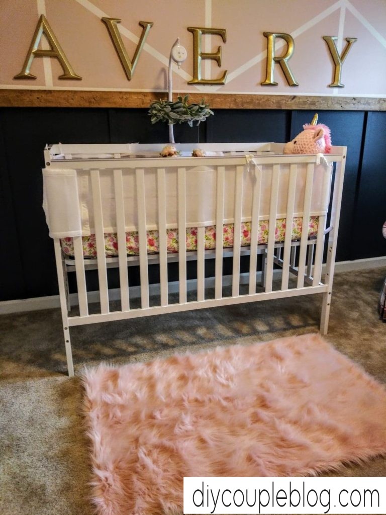 her nursery accent wall with pink fur rug