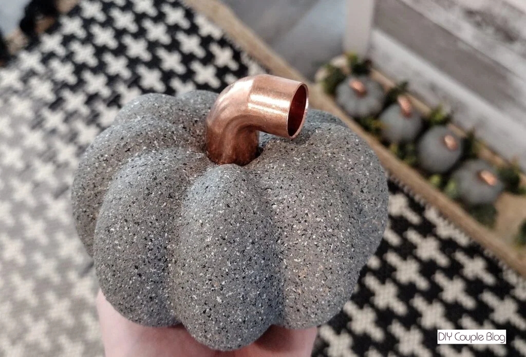 the final product of the DIY pumpkin after spray painted and adding the copper elbow stem