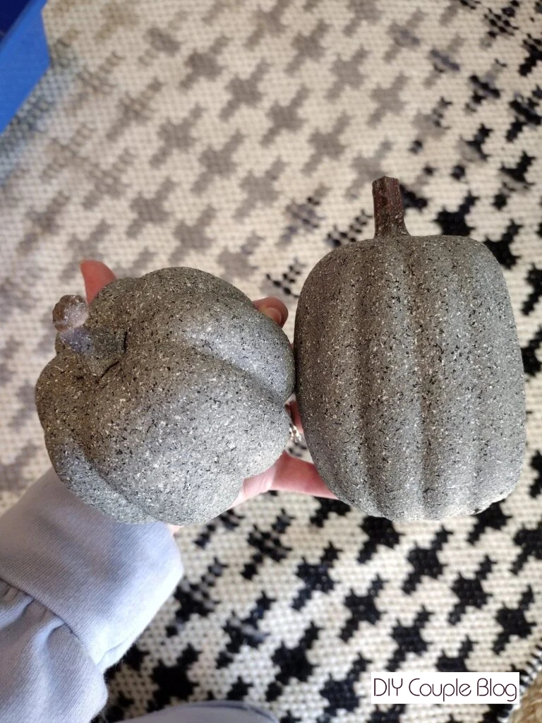 holding two foam DIY pumpkins up to show the texture of the stone spray paint