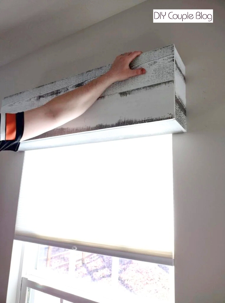 continuing to apply the whitewash wood boards to frame of the wood cornice boxes