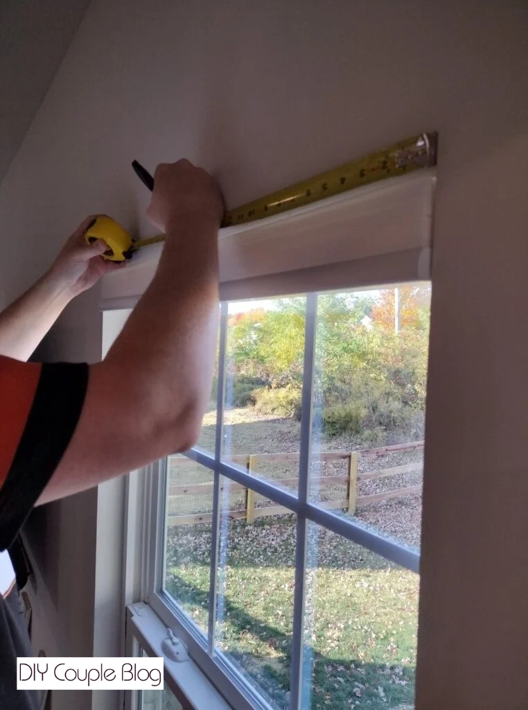 measuring the top of a window frame for a custom DIY cornice board