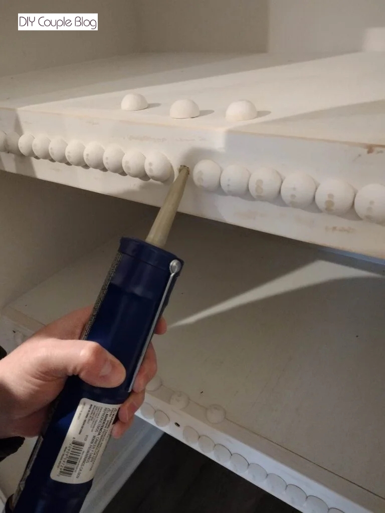 gluing wood bead in the missing spot of DIY pantry shelving
