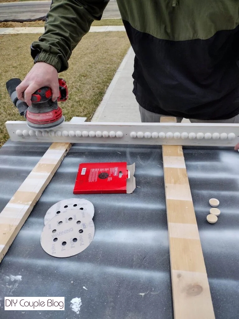 using sander to distress boards for front of DIY pantry shelving