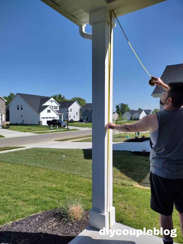 Close-up of a homeowner measuring correct privacy panel sizing for frame and composite decking 