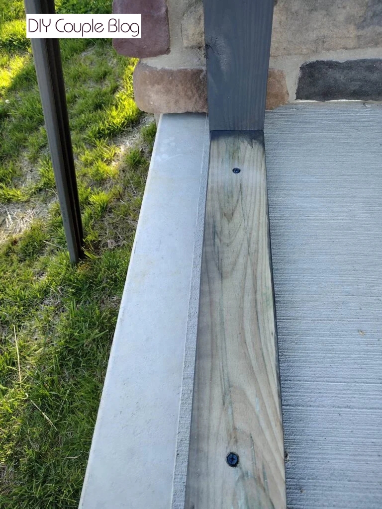 showing other side of the frame anchored to the concrete and up against the house