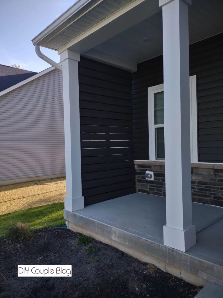 side view of a front porch with a dark gray composite deck privacy wall 