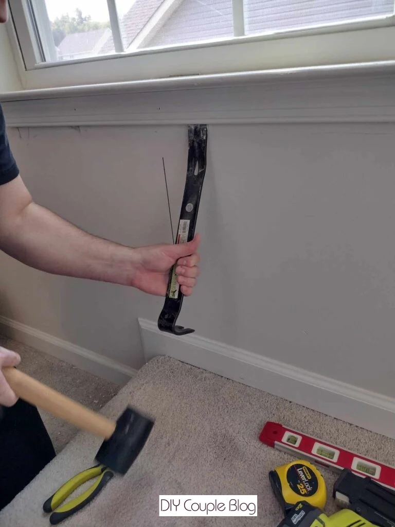 the process of taking off the trim at the bottom of window