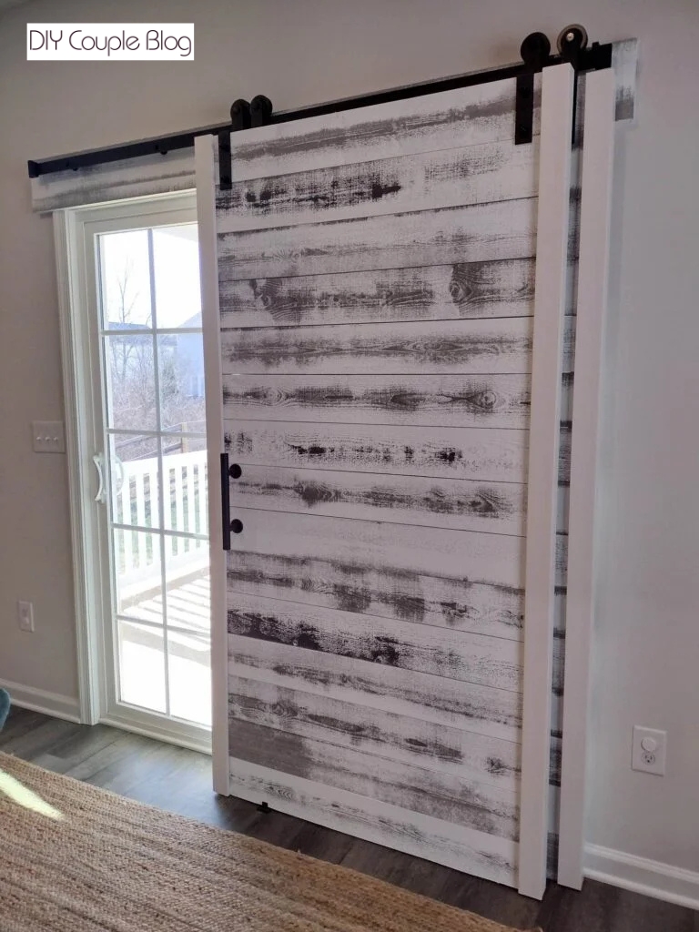 DIY barn door made with the same rustic barn wood planks as the accent wall