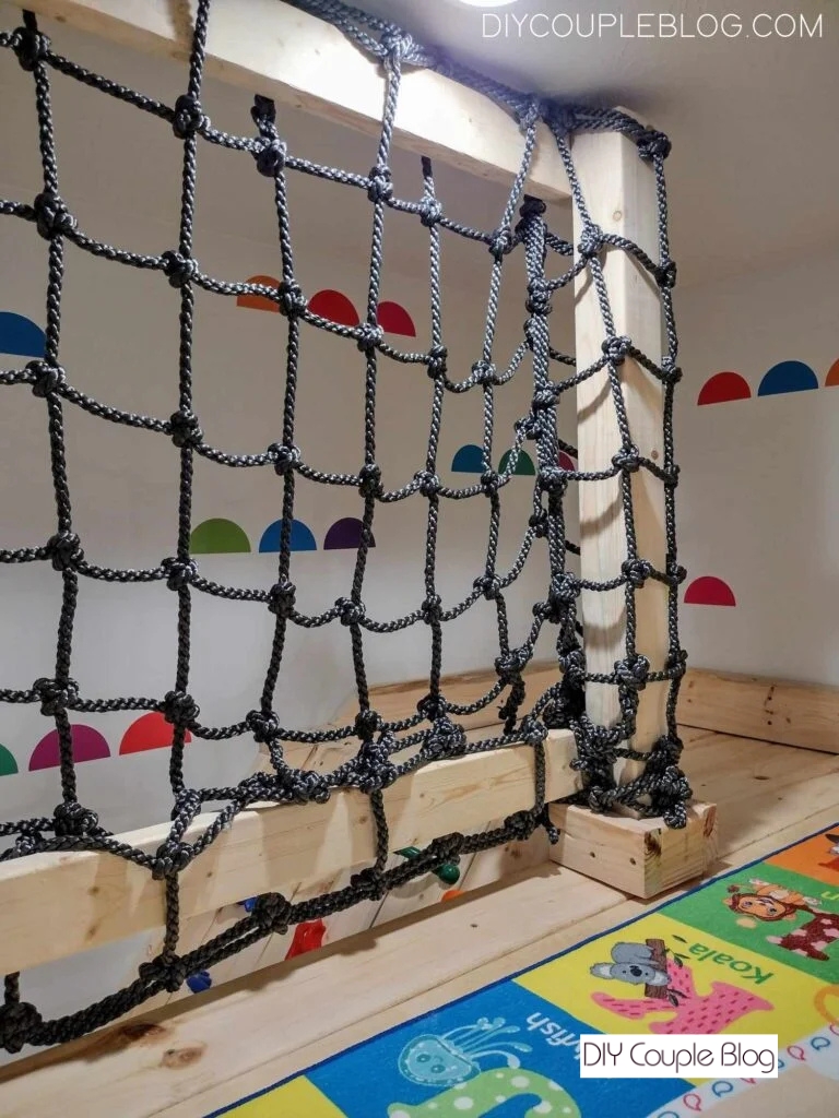 inside of the playground wood rail secured with a cargo net for a safety rail