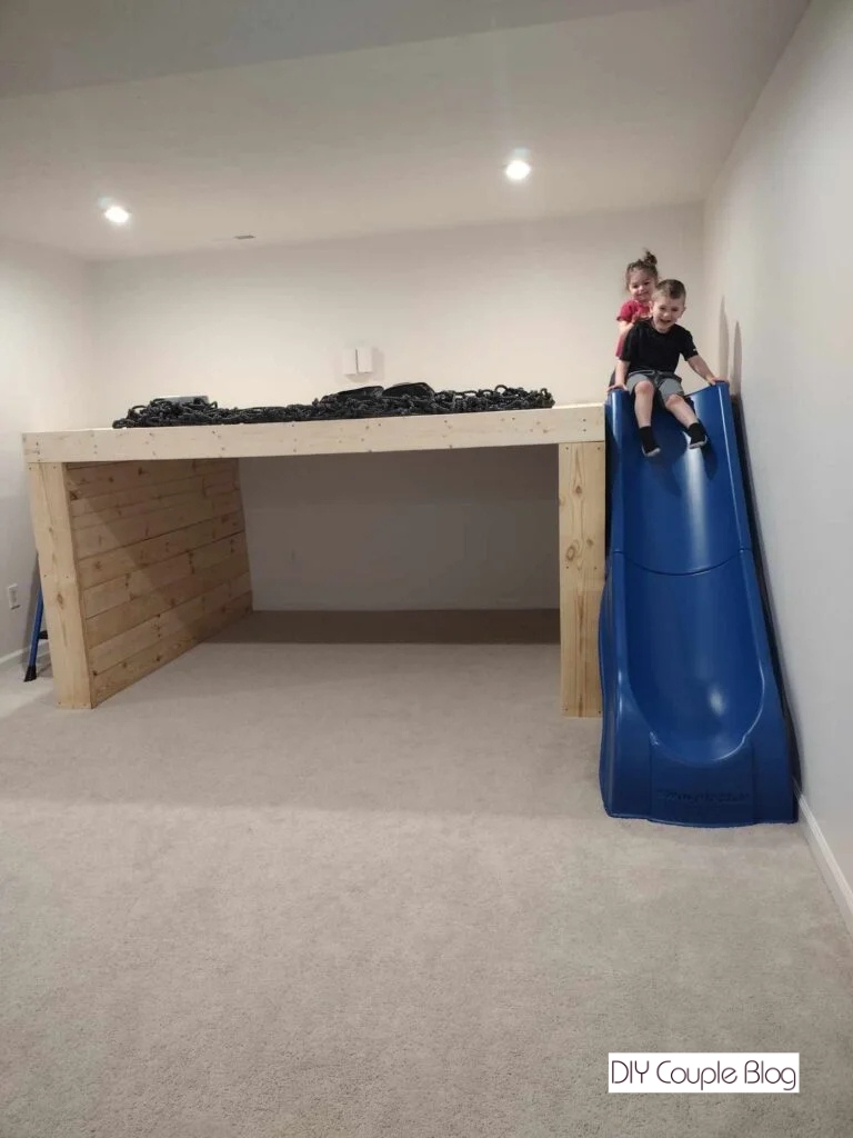 kids going down slide on unfinished playground 
