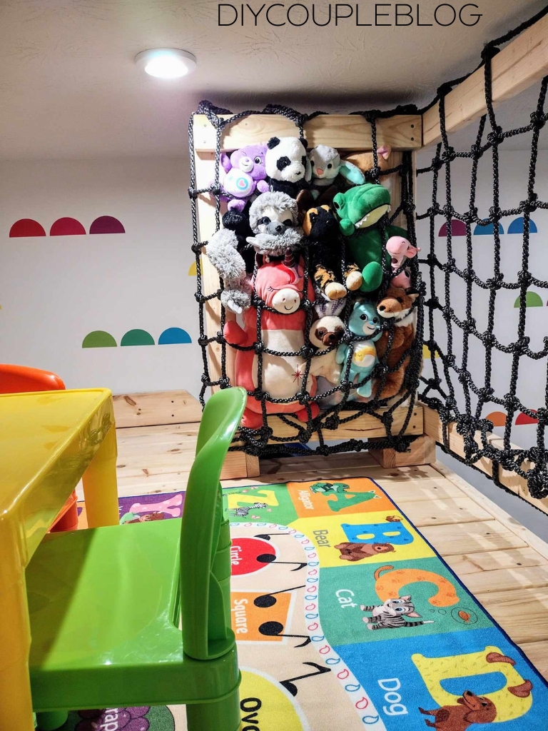 colorful fun kids' area with stuffed animal storage in cargo net and modern colorful wall