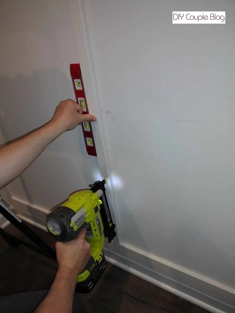 attaching the board to the wall while making sure its level