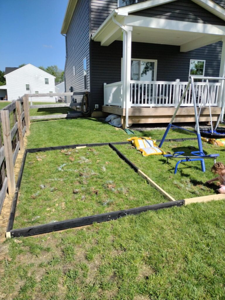 the side of the DIY sandbox attached to the playground border to make two separate play areas