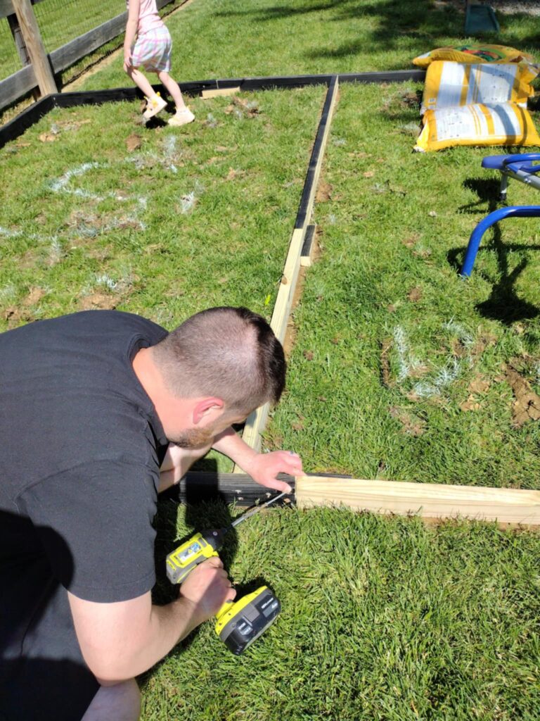 man installing the border for playground
