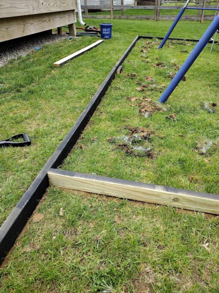connecting boards around swing set to make a playground border