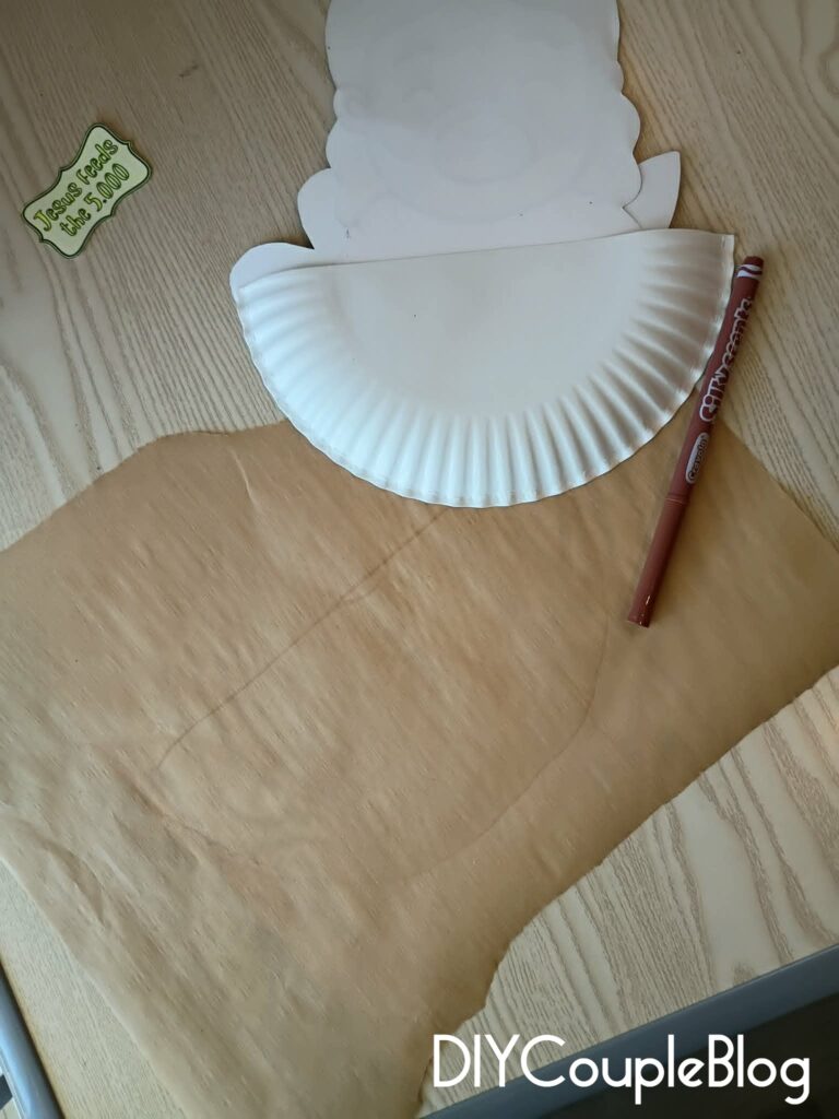 tracing a line same shape as the paper plate on brown parchment paper