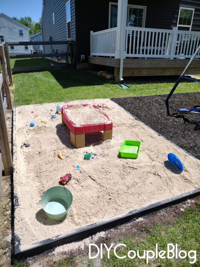 large DIY sandbox with border that goes around to playground area