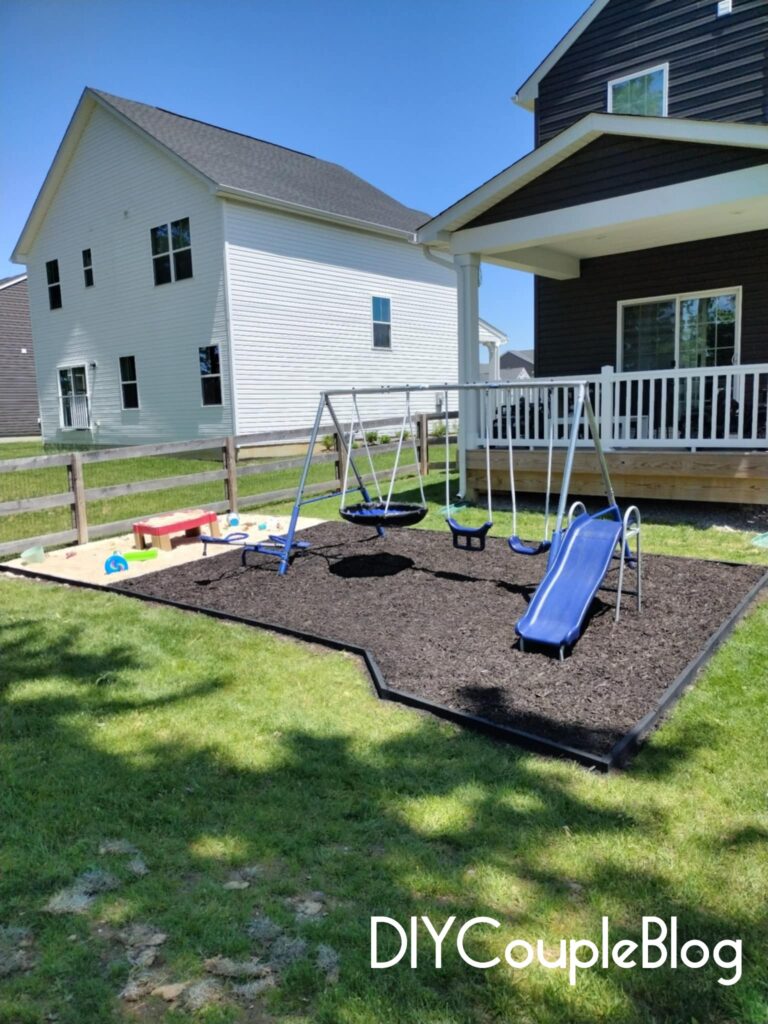 view of our finished playground in small backyard with mulch, sand and 2x4 treated wood border