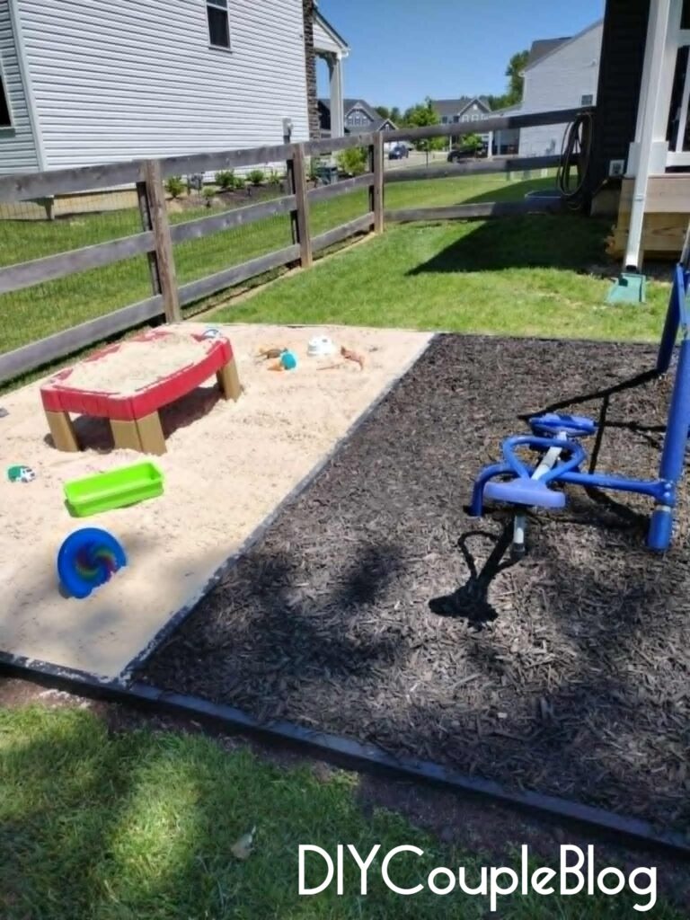 large sandbox joined to a large mulch play area